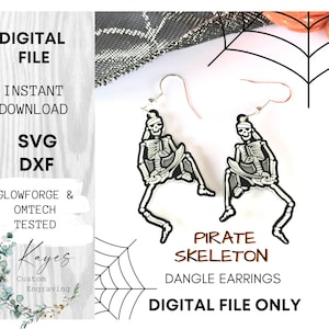 Op de afbeelding: Een paar hangende oorbellen met een piraten-skeletontwerp. De oorbellen zijn wit met zwarte details en hangen aan zilveren haken. De oorbellen worden getoond tegen een zwarte en oranje spinnenwebachtergrond.  ALLEEN DIGITALE BESTAND.