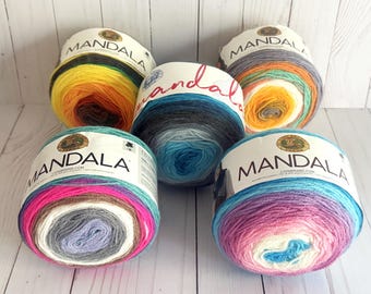 May include: Five skeins of Mandala yarn in different color combinations. The yarn is a gradient style with multiple colors in each skein. The colors include pink, purple, blue, teal, gray, white, yellow, orange, and brown.