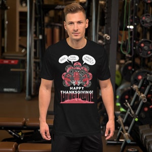 May include: A black t-shirt with a graphic of a turkey with the text "Ouch... Kinda tickles... Where's Francis?" and "Happy Thanksgiving!" The turkey is red and black and has a menacing expression.