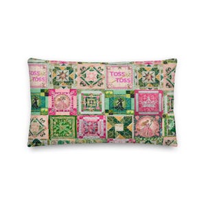 Peut inclure: Coussin rectangulaire décoratif avec un motif patchwork. Le coussin présente des carrés dans les tons de rose, de vert et de blanc, avec des motifs floraux et géométriques brodés. Les mots "TOSS TOSS" sont imprimés sur le coussin.