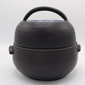 Round pottery casserole dish with a lid, can be use for cooking and Serving, made from black stoneware and glazed in blue