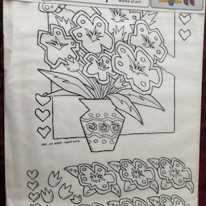 May include: A pack of EZ Paint Transfers with iron-on designs. The package shows a black and white floral design in a vase, with additional floral and heart embellishments. Text on the package reads "Even beginners can create wearable works of art!"