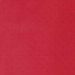 May include: Red fabric with a small, dark, polka dot pattern.