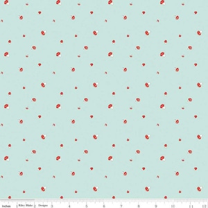 May include: A light blue fabric with a repeating pattern of red and white mushrooms. The fabric is 12 inches wide and has a ruler along the bottom edge.