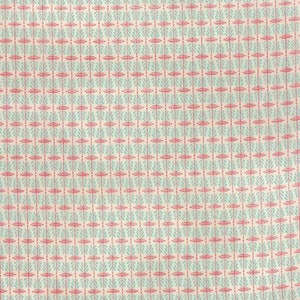 May include: A white fabric with a repeating pattern of small blue and pink geometric shapes.
