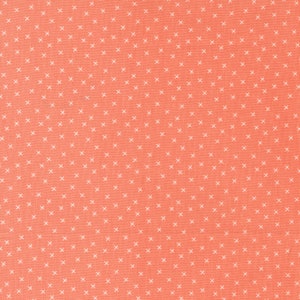 May include: Coral-colored fabric with a repeating pattern of small white crosses. The fabric has a textured appearance, and the crosses are evenly spaced across the surface. This textile is suitable for various sewing and crafting projects.