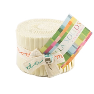 May include: A roll of cream-colored fabric strips, secured with a ribbon bow. The ribbon is printed with the word "moda" and other text. A colorful tag with the words "BELLA SOLIDS moda" is attached to the roll.