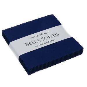Puede incluir: Una pila de cuadrados de tela azul marino con una etiqueta blanca que dice "moda Bella Solids by moda".