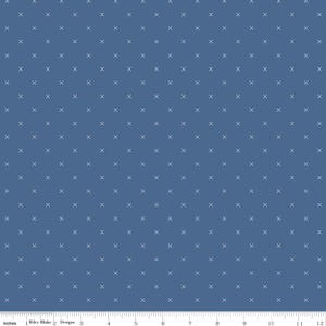 May include: Blue fabric with a repeating pattern of small white crosses. The fabric is a solid blue color, and the crosses are evenly spaced across the surface. The image includes a ruler along the bottom edge, showing inches.