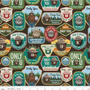 May include: A brown fabric with a repeating pattern of colorful patches featuring a cartoon bear ranger. The patches have text that says "Only You" and "Protect Wildfires".