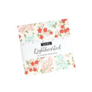Könnte beinhalten: Eine Packung Stoffquadrate mit einem floralen Druck in Rosa-, Rot- und Blautönen auf weißem Hintergrund. Die Stoffquadrate sind mit "Lighthearted by Camille Roskelley" beschriftet.