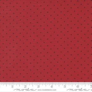 May include: Red fabric with a small navy blue star pattern. The fabric is measured with a ruler in inches.