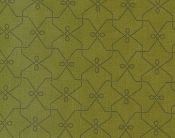 Pode incluir: Close-up de um tecido texturizado com um padrão geométrico repetitivo. O fundo é verde-oliva suave, sobreposto por um design cinza escuro com formas interconectadas e laços decorativos. O tecido tem uma aparência sutil e tecida.