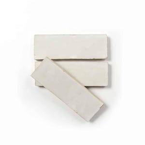 May include: Three off-white rectangular tiles are arranged on a white background. The tiles have a slightly textured surface and a rustic, handmade appearance. The tiles are likely for use in home decor or construction projects.