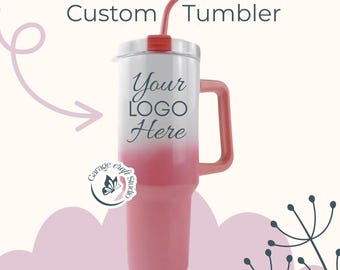 May include: A custom tumbler with a pink ombre design, a handle, and a red straw. The text "Custom Tumbler" is at the top, and "Your Logo Here" is printed on the front. The tumbler has a white lid and a pink handle.