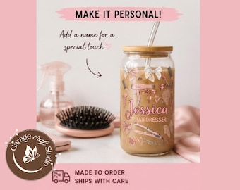 May include: A personalized glass tumbler with a bamboo lid and straw, featuring the name "Jessica Hairdresser" in pink script. The design includes hair styling tools and bows. The words "Make it Personal!" are at the top.