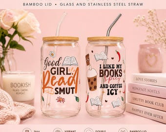 May include: Two clear glass Libbey cans with bamboo lids and stainless steel straws. One reads "Good Girl Read Smut" and the other says "I like my books spicy and coffee icy." Each has a floral and book design.
