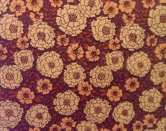 May include: A vintage wallpaper pattern with a repeating design of white and orange flowers on a dark brown background.