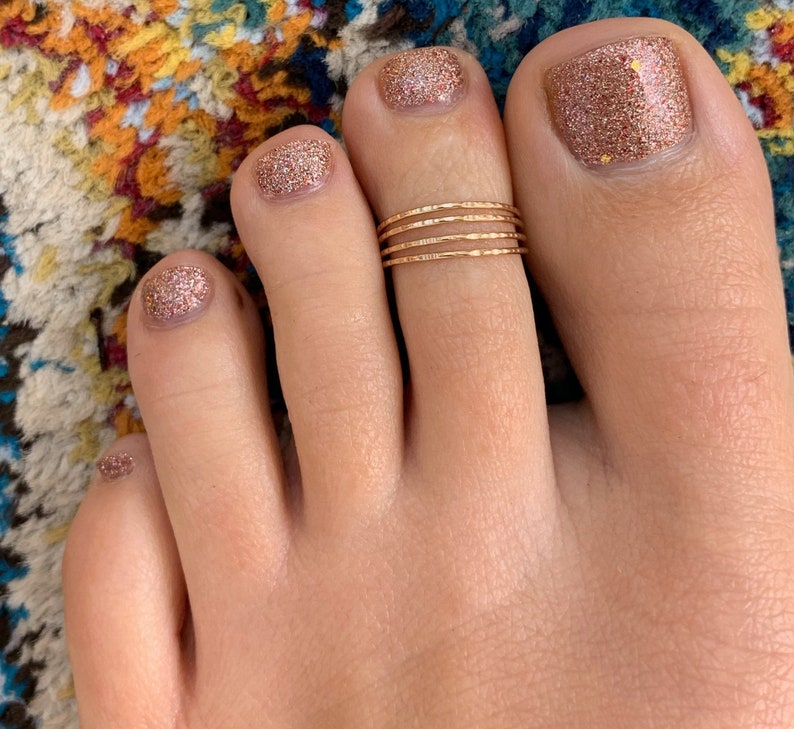 A gold toe ring perfect for women - four strands of gold wire in an adjustable toe ring, one size fits all. The perfect gift!