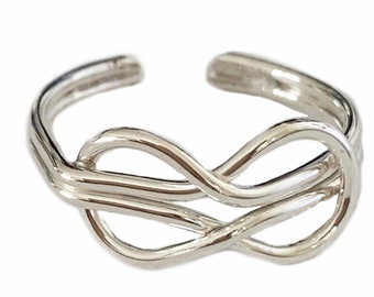 May include: Silver infinity knot toe ring. The ring is made of a single piece of wire that is twisted into an infinity knot shape.