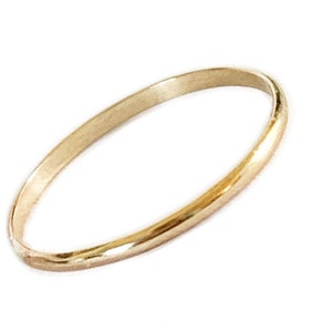 May include: A simple, thin gold band ring.