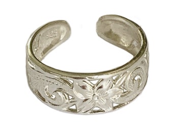 May include: Silver toe ring with a floral design. The ring is adjustable and has a delicate, intricate pattern.