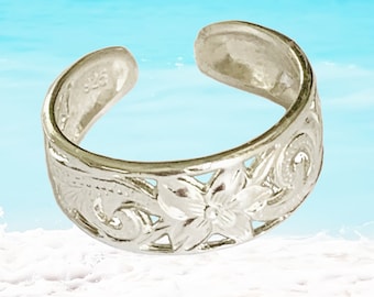 May include: Silver toe ring with a floral design. The ring is adjustable and has a delicate, intricate pattern.