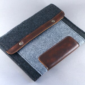 Manchon en feutre pour reMarkable 2 et Paper Pro. Un étui avec porte-stylo, poches et détails en cuir combinés à du feutre gris bicolore.