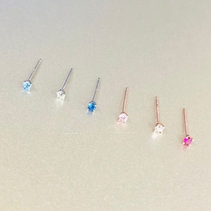 以下が含まれることがあります： 異なる色の宝石が付いたスタッドピアスが6ペア。ピアスはシルバーとゴールドの色です。宝石はブルー、ピンク、レッド、クリアです。