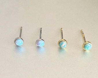 Puede incluir: Cuatro pares de pendientes de botón de ópalo. Dos pares tienen postes de plata y dos pares tienen postes de oro. Los ópalos son de color azul claro.