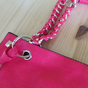 A gorgeous red leather tote bag with decorative square metal edges and red leather tassels