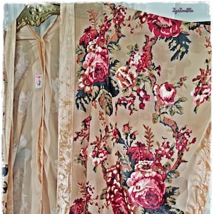 May include: A beige floral kimono with a velvet trim and a matching sheer underlayer. The kimono features a large-scale floral pattern in shades of red, pink, and brown. The text "ZyaZyaBlu" is in the upper right corner.