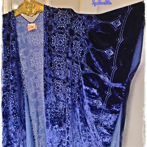 May include: A dark blue velvet kimono with a white geometric pattern. The kimono is hanging on a gold-colored hanger. The fabric has a soft, textured appearance. The text "ZzaZzuBlu" is in the upper right corner.