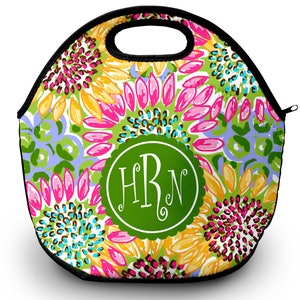 May include: A round, green and white lunch bag with a floral pattern and a green circle with the monogram "HBN" in white.