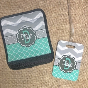 May include: A luggage tag and a luggage handle wrap with a gray and teal chevron pattern. The tag and wrap are personalized with the letter "D" and the name "Diane".