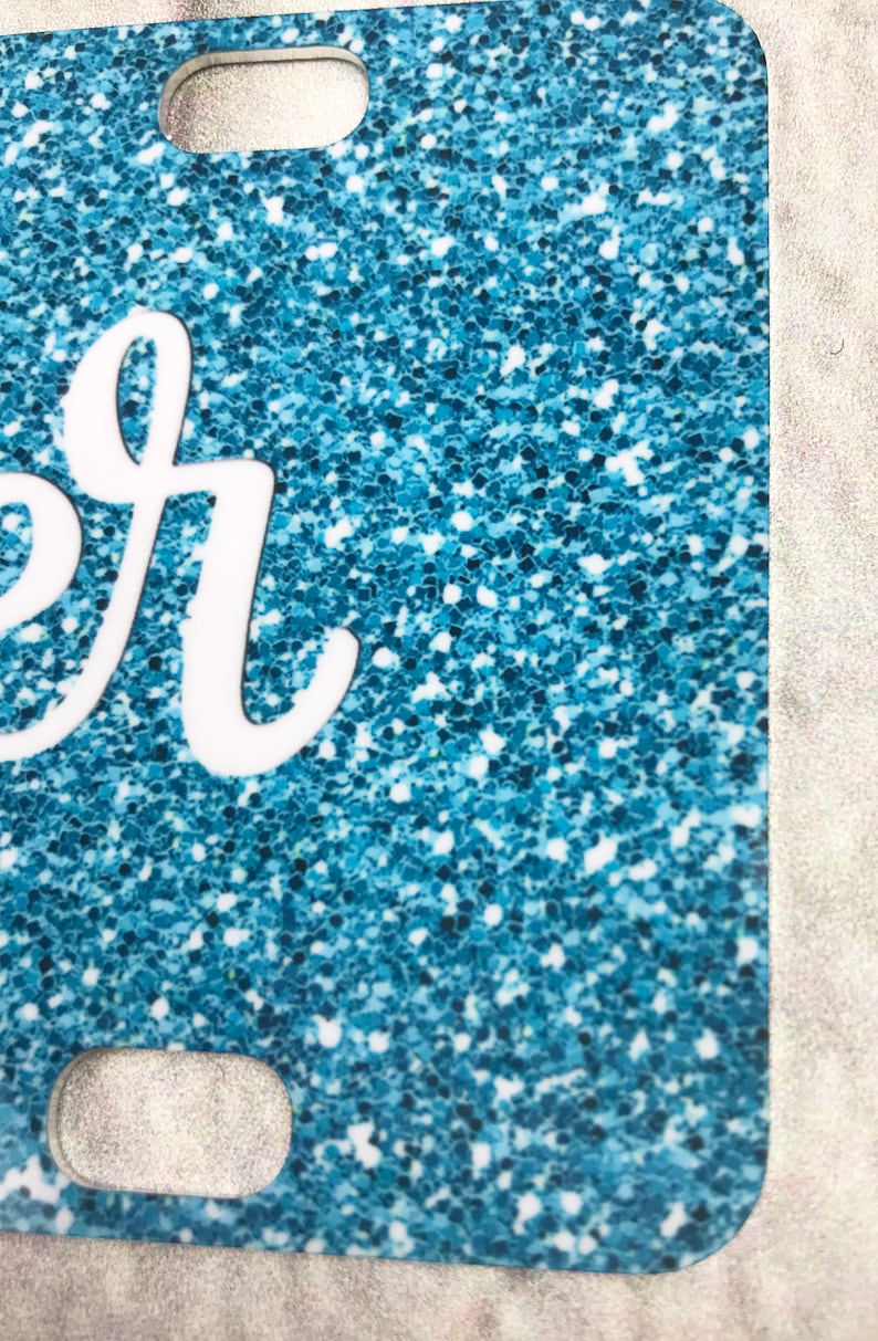 May include: A blue glitter phone case with a white "er" design.