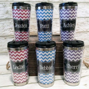 May include: Six personalized travel mugs with chevron patterns in red and white, blue and white, and purple and white. Each mug has a black label with a name on it: Jessica, Patti, Ashley, Leslie, Debbie, and Sherri.