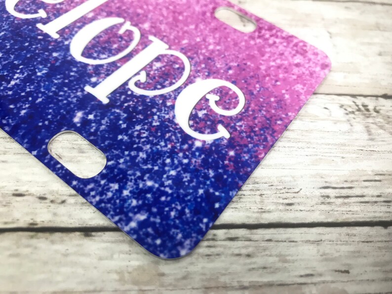 K&ouml;nnte beinhalten: Nahaufnahme einer glitzernden Nummernschild in Lila und Blau mit dem Wort "Hope" in Wei&szlig;.
