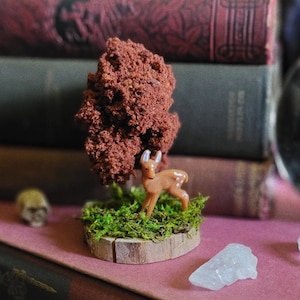 deer under an autumn tree on moss