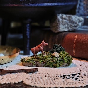 mini nature diorama - cow walking uphill