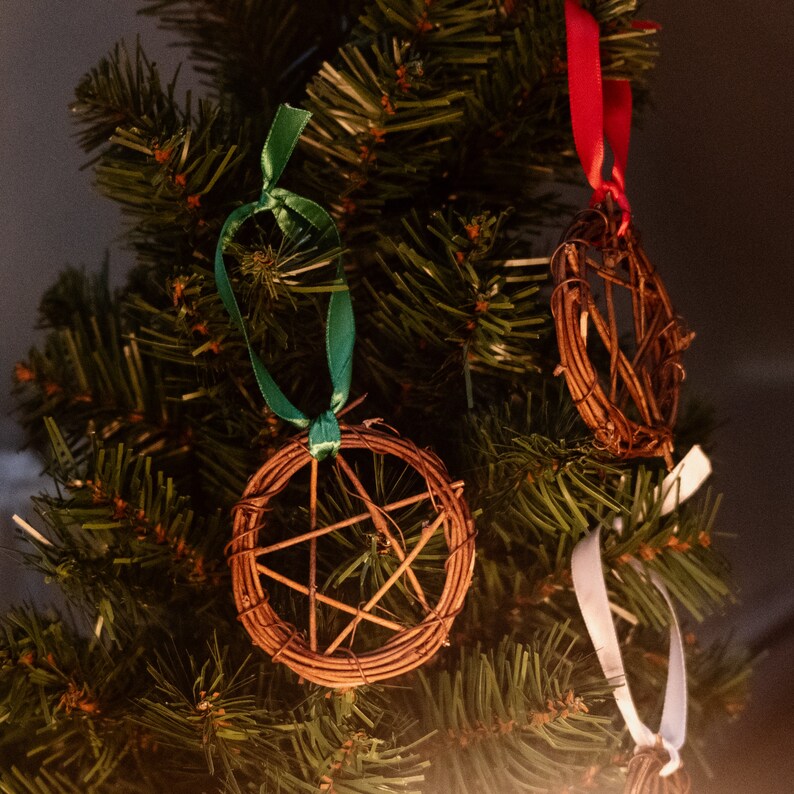 woven grapevine with ribbon tied on it to create a pentacle ornament