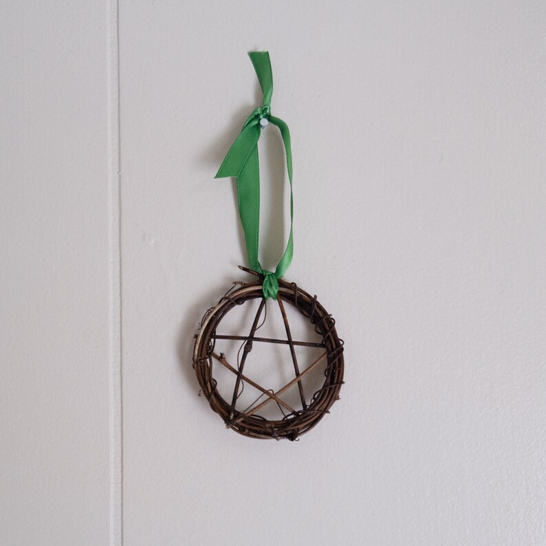 woven grapevine with ribbon tied on it to create a pentacle ornament