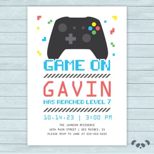May include: A blue, red and black invitation with a pixelated game controller graphic. The text reads "Game On Gavin Has Reached Level 7 10.14.23 | 3:00 PM The Johnson Residence 1234 Main Street | Des Moines, IA Please RSVP to Jane at 555-555-5555".