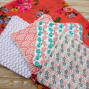 Peut inclure: Cinq tampons démaquillants réutilisables avec différents motifs. Les tampons sont faits d'un tissu doux et naturel et sont conçus pour être doux pour la peau. Les motifs comprennent un motif chevron, un motif de vagues, un motif de vélo, un motif floral et un motif à pois.