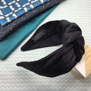 May include: Black knotted headband with a fabric label that reads "CUCCIOTORINO - Be yourself, love yourself".