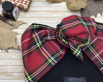 May include: Red and black plaid headband with a large bow. The headband is made of a soft, stretchy fabric and has a black elastic band. The headband is tied in a bow on the top of the head. The headband has the text "Cucitorino Be yourself love yourself" on the back.