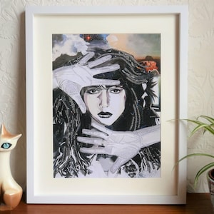 May include: A black and white collage print of a woman with long dark hair, her face partially obscured by white hands. The background is a blurry image of a cityscape.