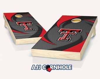 May include: Two wooden cornhole boards with a black and red design. Each board features a large red and black "T" logo, a circular hole, and a red and black swirl pattern. The boards are set against a white background.