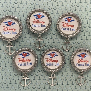 May include: Six silver bottle cap charms with a Disney Cruise Line logo and a red Mickey Mouse head. Each charm has a silver anchor attached.