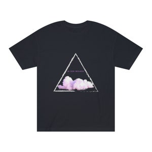 Puede incluir: Una camiseta azul marino con un gráfico de triángulo blanco que presenta una nube rosa y el texto "in den wolken".